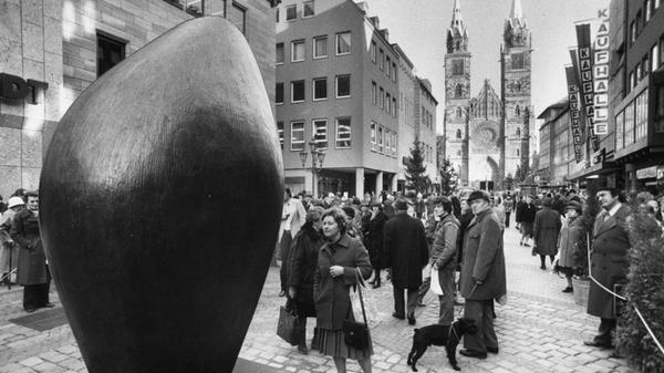 Für Aufsehen und Gesprächsstoff sorgte im Dezember 1979 die 2,44 m große Bronzeplastik „Großer Totemkopf“ des berühmten Bildhauers Henry Moore nach ihrer Enthüllung in der Karolinenstraße unweit der Lorenzkirche. Die Karstadt AG hatte die abstrakte Skulptur für 400 000 DM gekauft und der Stadt Nürnberg geschenkt. Die Meinungen waren geteilt. „Ohr zur Welt“, „Kaffeebohne“ oder „Knoblauchzehe“, so lauteten einige der Assoziationen der Betrachtenden auf Nachfrage unseres Redakteurs. Unser Foto zeigt die Rückseite der Plastik, die auch heute noch an dieser Stelle zu finden ist.