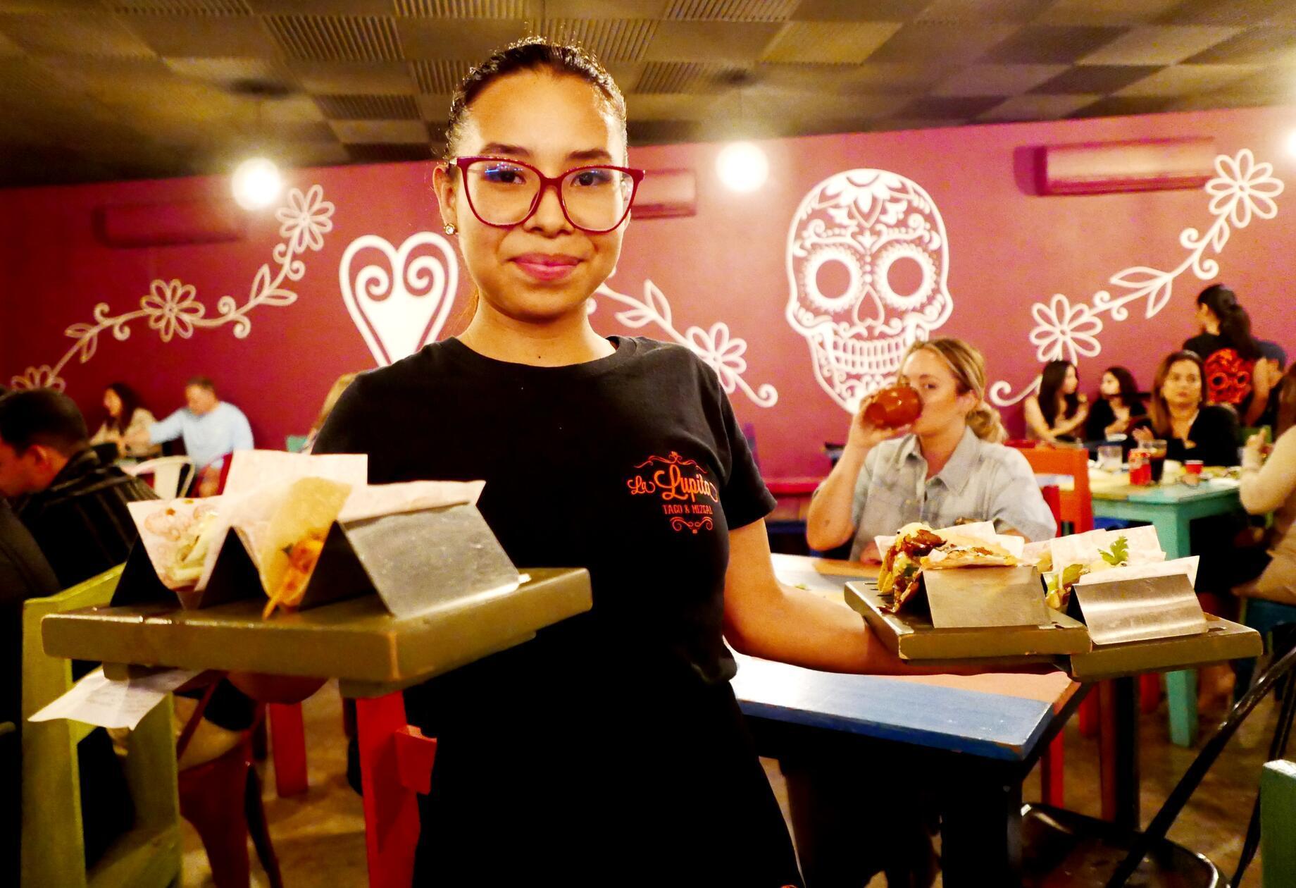 In einer authentischen Taqueria serviert diese Kellnerin leckere Tacos.