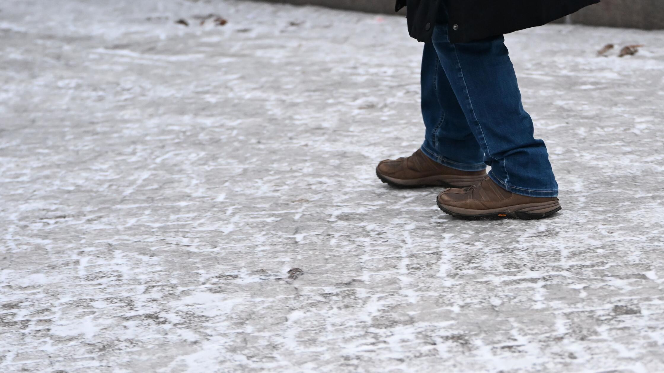 30.01.2026, Berlin: Ein Frau rutscht auf einer ver