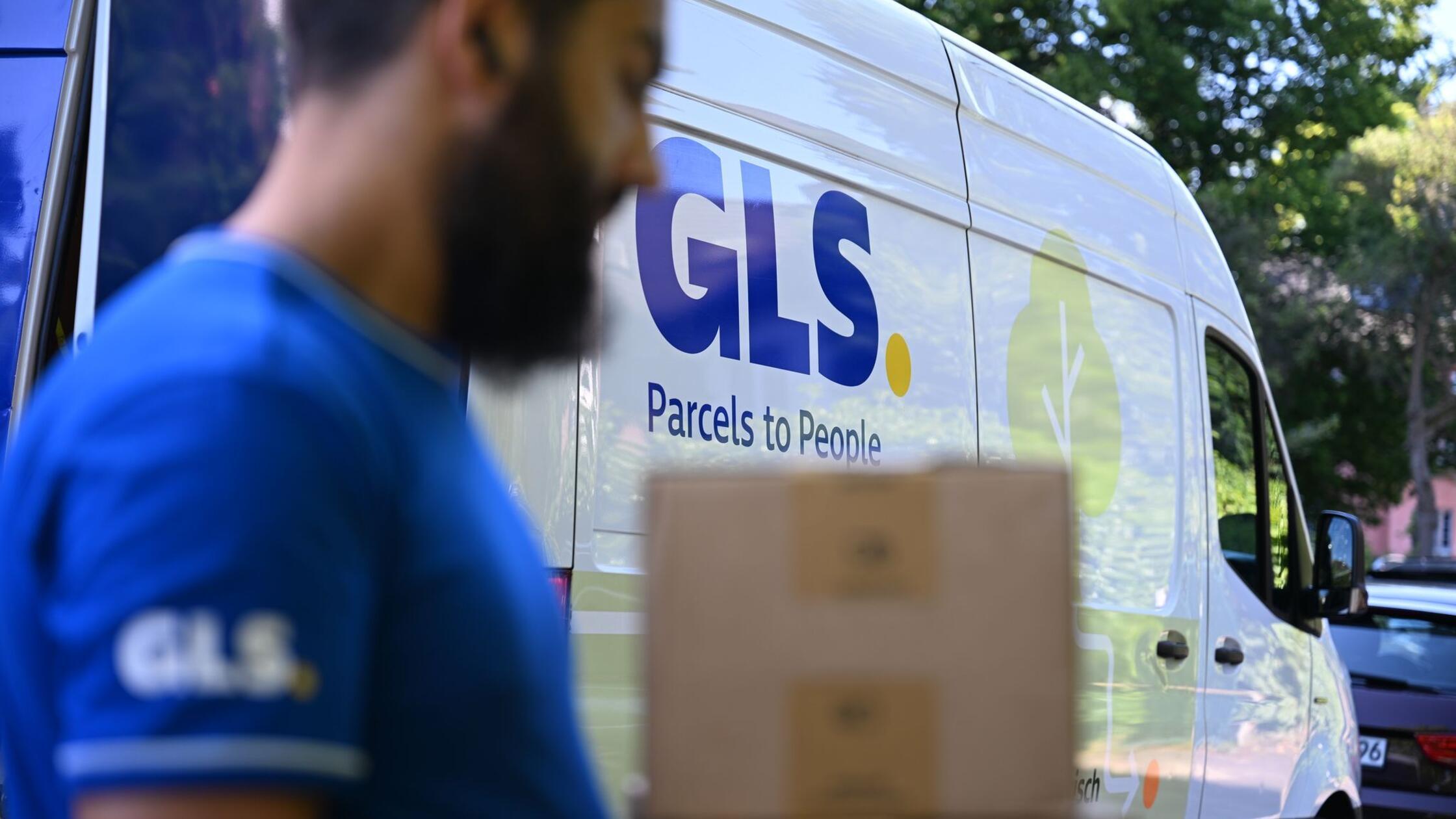 Ein Paketbote des Paketdienstleisters GLS geht mit