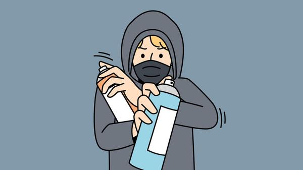 Mann mit Kapuze und Farbspray