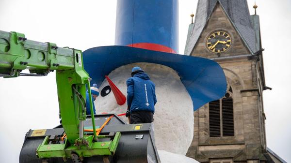 Zwei Männer bringen den Mund an einem riesigen Sch