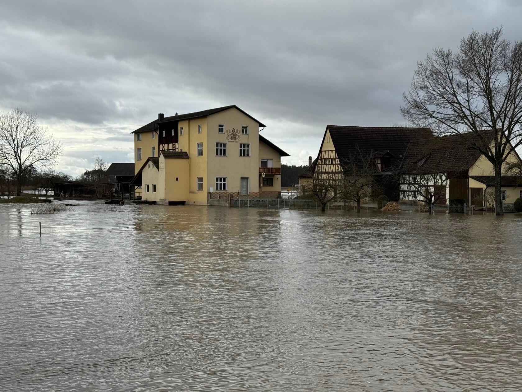 Die Hochwassersituation in Teilen Frankens hat sich zum Freitag weiter angespannt. Besonders betroffen ist unter anderem die Aisch im Bereich Adelsdorf und Willersdorf. Ganze Straßen stehen Unterwasser. Auch Häuser stehen inmitten des reißenden Hochwassers. Mittlerweile gilt die Meldestufe 3. Die Ursache sind anhaltendes Tauwetter sowie zusätzliche Niederschläge, durch die die Flüsse deutlich über ihre Ufer getreten sind. So sind ganze Landstriche vom Hochwasser betroffen. Die Einsatzkräfte beobachten die Pegelstände weiterhin genau.