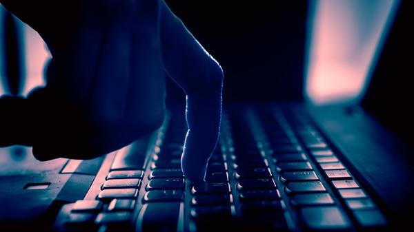 Finger tippt auf einer Tastatur, dunkle Umgebung u