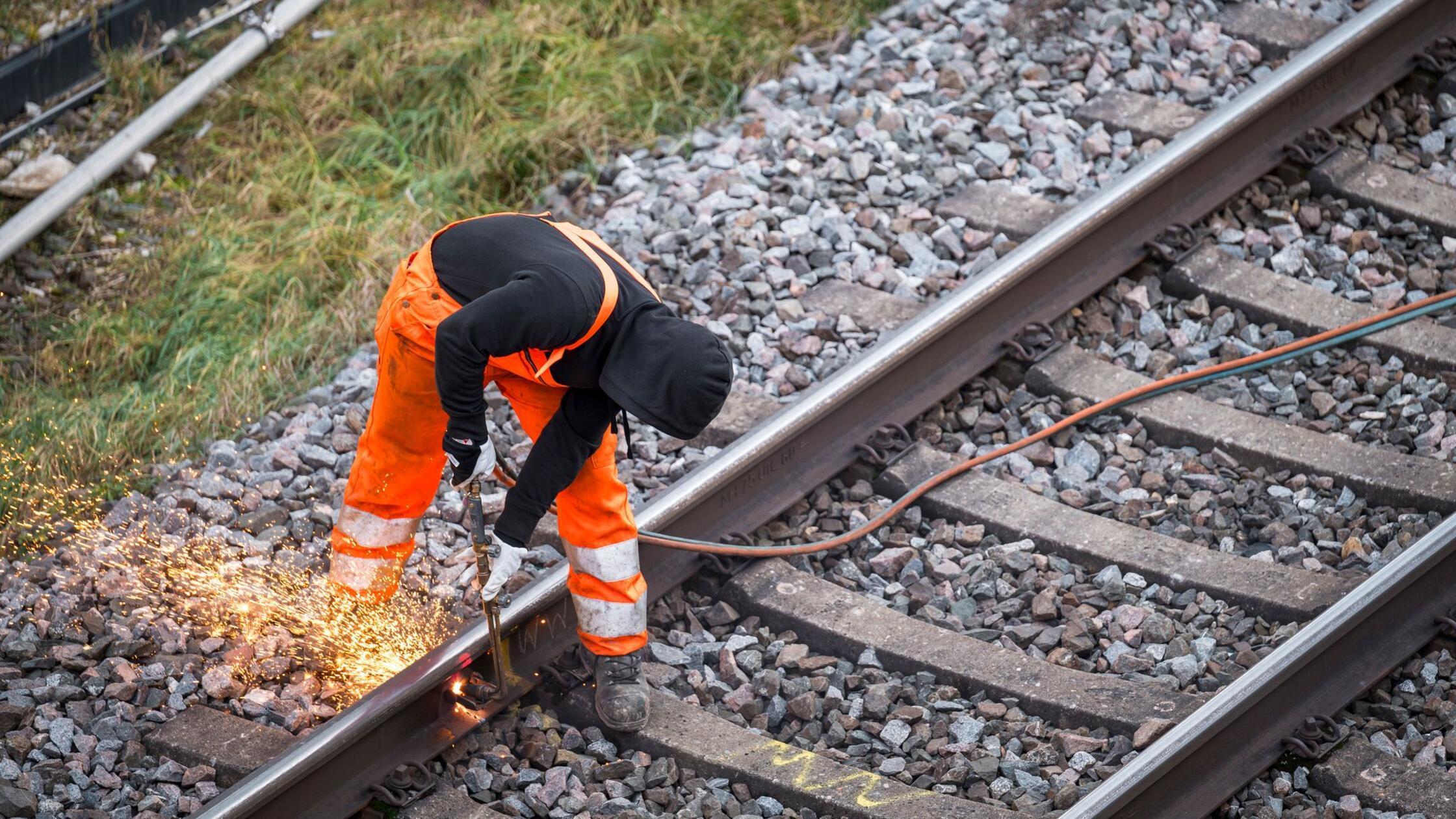 Ein Arbeiter zerteilt ein altes Bahngleis an der B