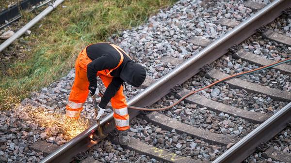 Ein Arbeiter zerteilt ein altes Bahngleis an der B