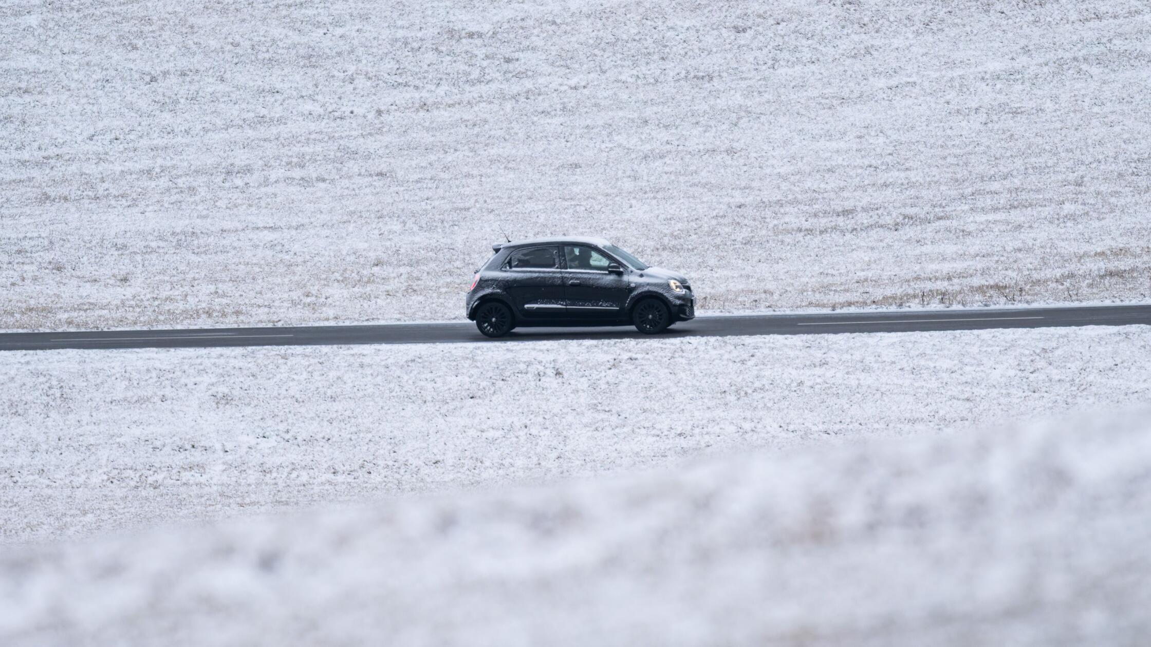 Ein Auto fährt auf einer Landstraße an leicht zuge