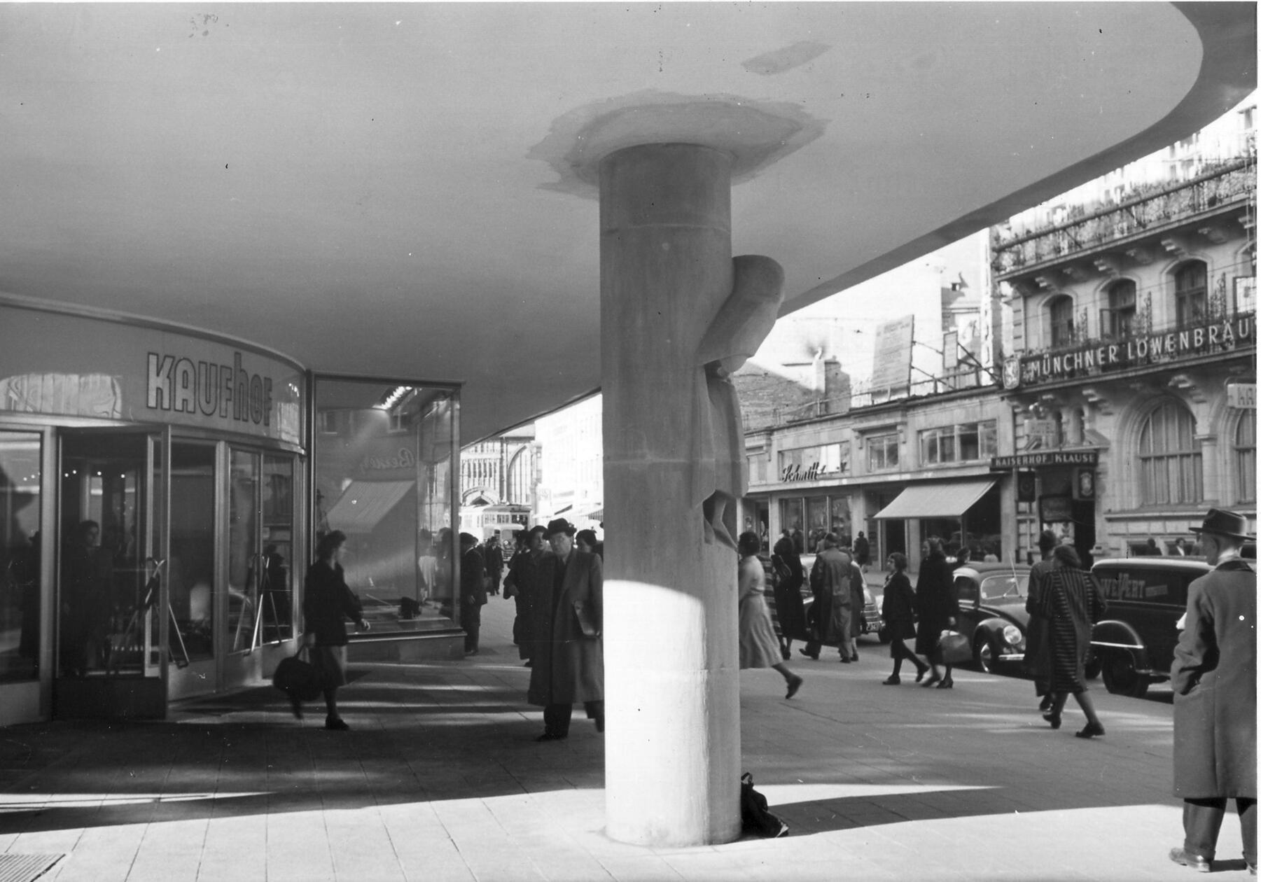 Aus der Säule am Südosteingang des Kaufhofgebäudes ragte fast plastisch „Der Rufer“ hervor. Die in den Sandstein eingearbeitete Figur stammte von dem Bildhauer Karl Knappe. Die Aufnahme entstand kurz nach der Eröffnung.