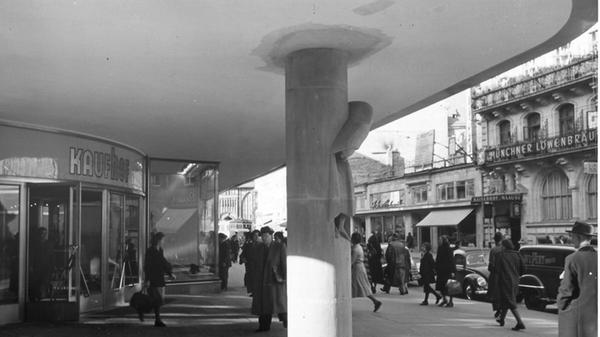 Aus der Säule am Südosteingang des Kaufhofgebäudes ragte fast plastisch „Der Rufer“ hervor. Die in den Sandstein eingearbeitete Figur stammte von dem Bildhauer Karl Knappe. Die Aufnahme entstand kurz nach der Eröffnung.