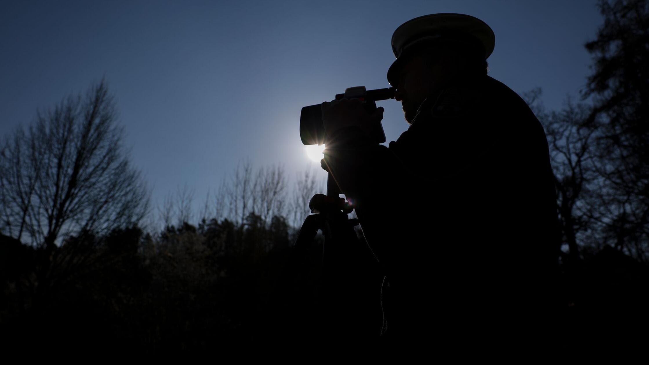 Ein Polizist misst mit einem Laserhandmessgerät (L