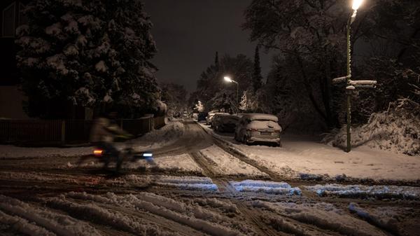 Ein Radfahrer fährt auf einer schneebedeckten Stra
