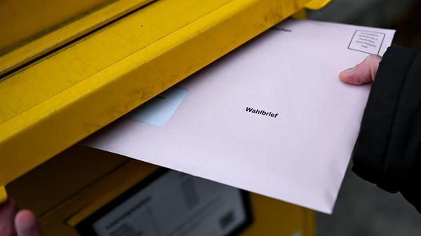 Eine Frau wirft einen Wahlbrief für die Kommunalwa