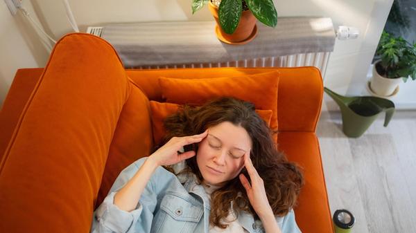 Junge Frau liegt mit geschlossenen Augen und den H