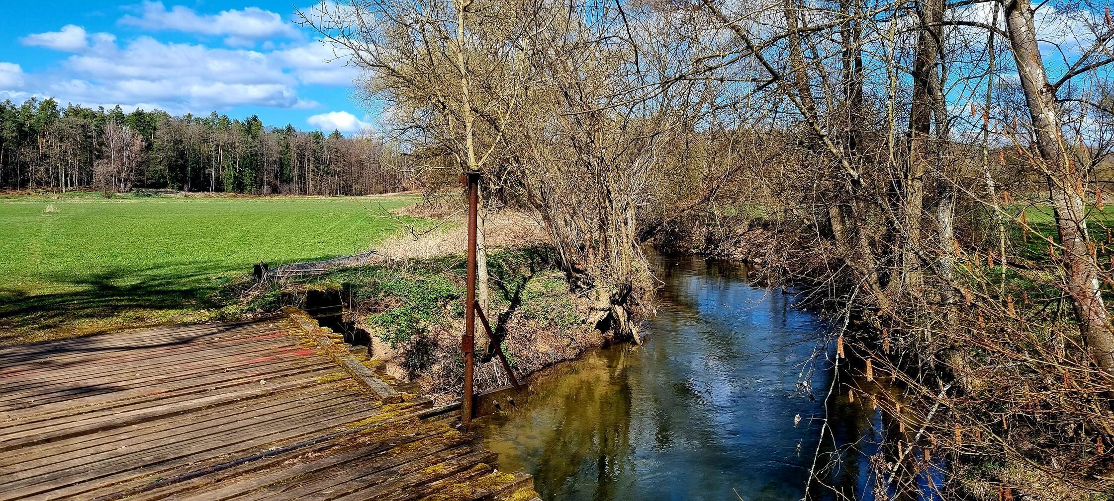 An der Schwarzach bei Wendelstein mit alter Brücke ei schönen Sonne/Wolkenmix.
