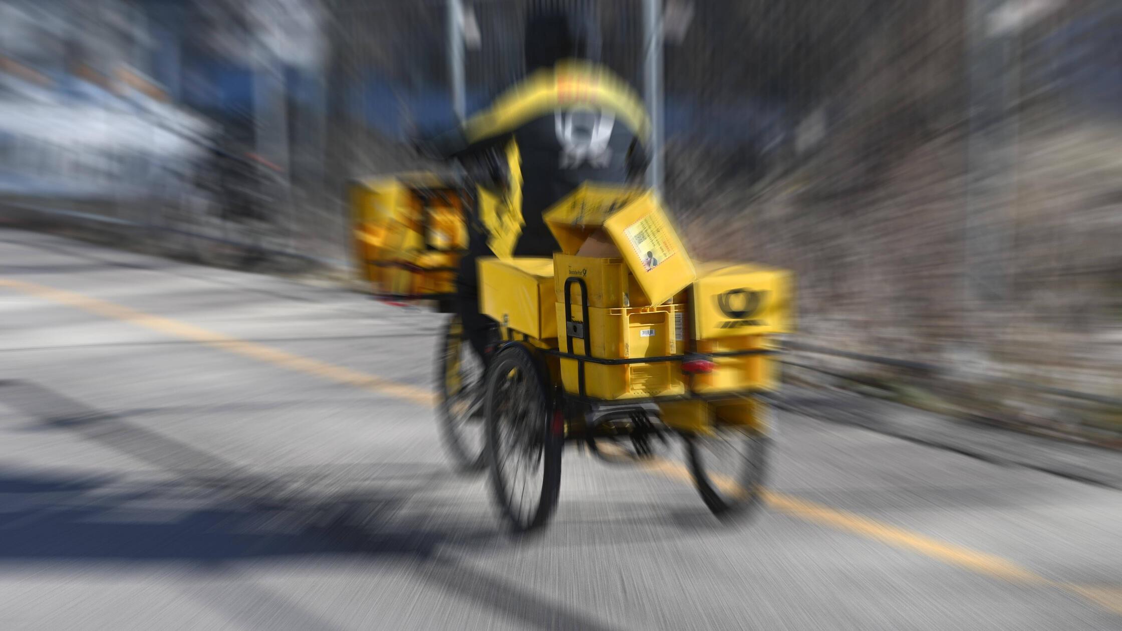 Themenbild Post,Postbote faehrt mit dem Fahrrad du