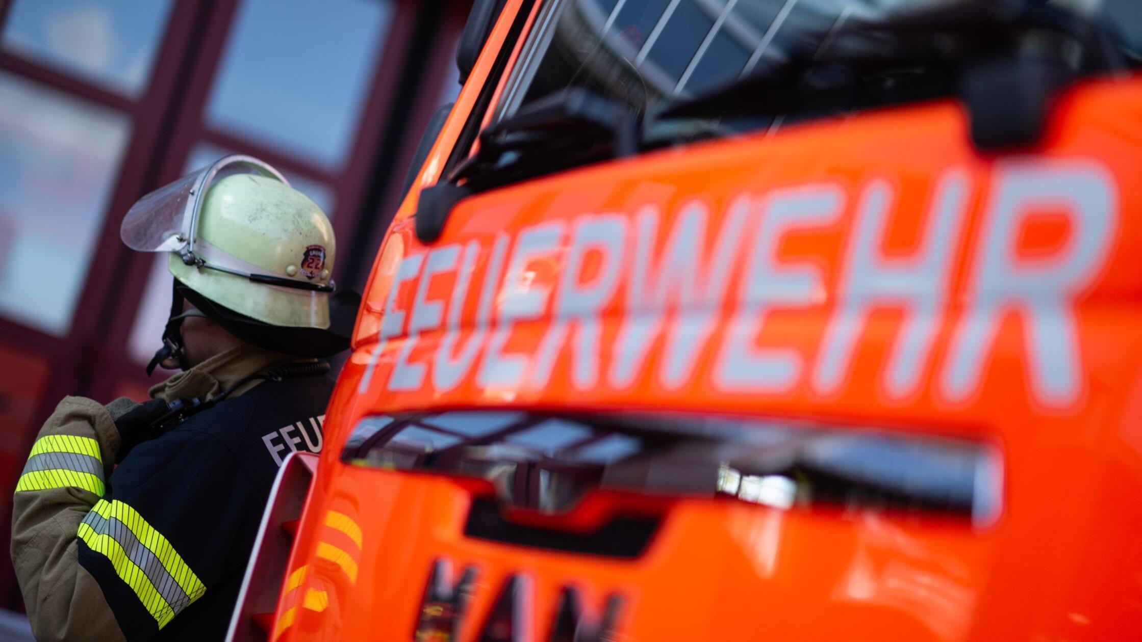 Eine Einsatzkraft der Feuerwehr steht neben einem 