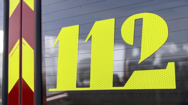 Neongelbe Notrufnummer 112 auf einer Fahrzeugschei