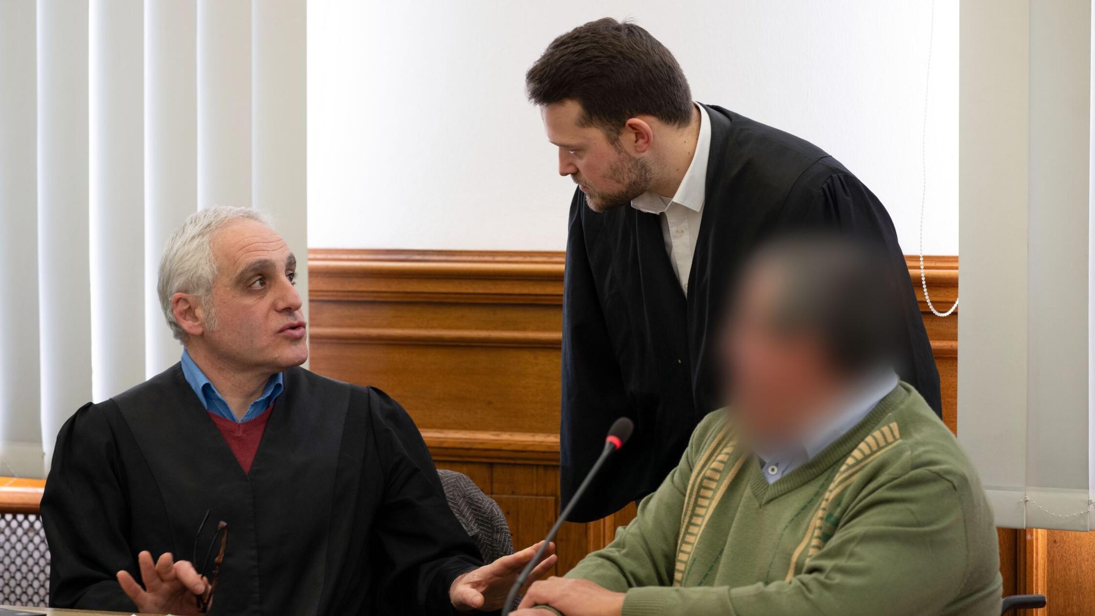 Der Angeklagte (r) unterhält sich vor dem Beginn d