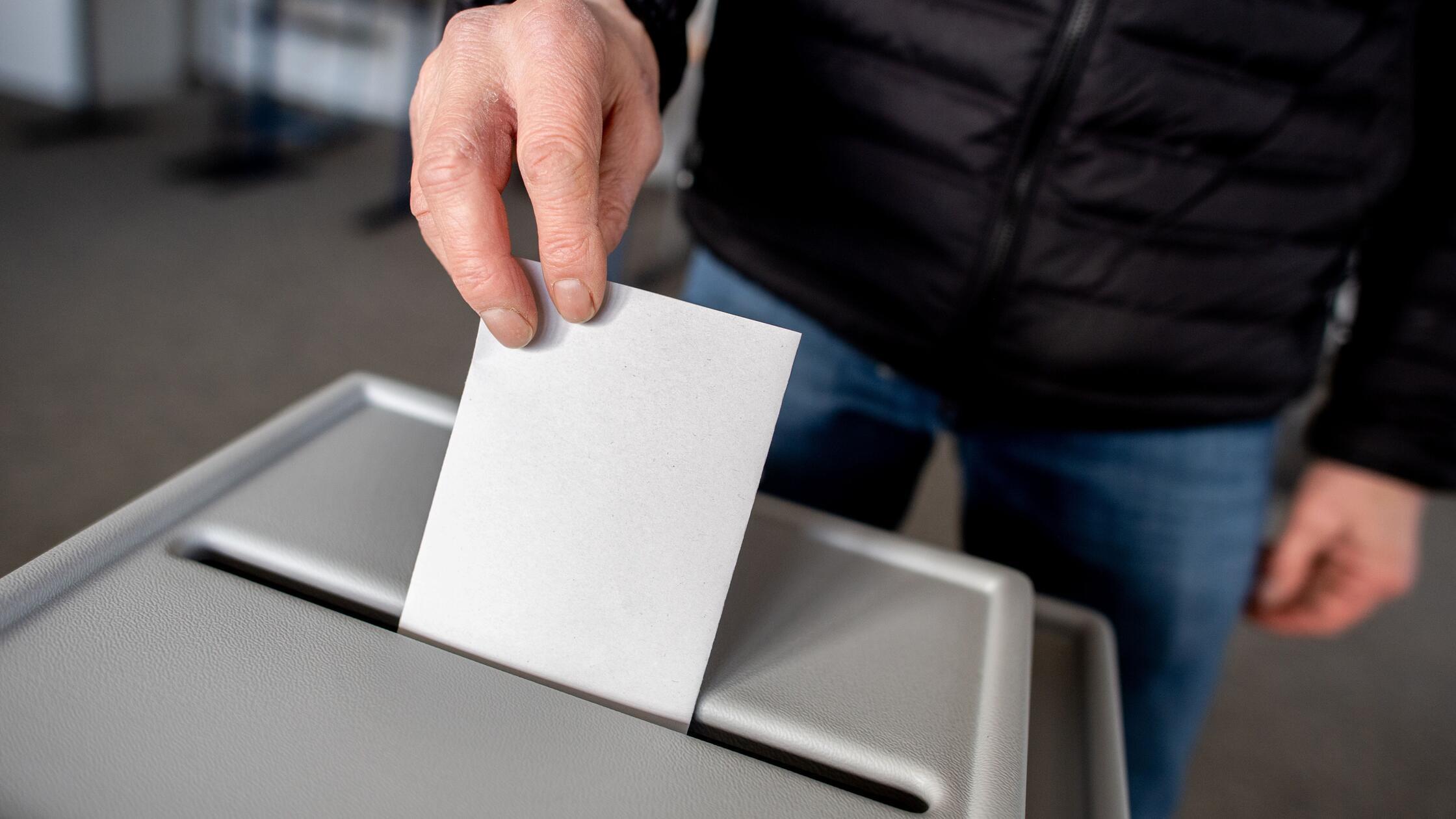 Ein Wähler wirft in einem Wahllokal seinen Stimmze