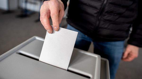 Ein Wähler wirft in einem Wahllokal seinen Stimmze