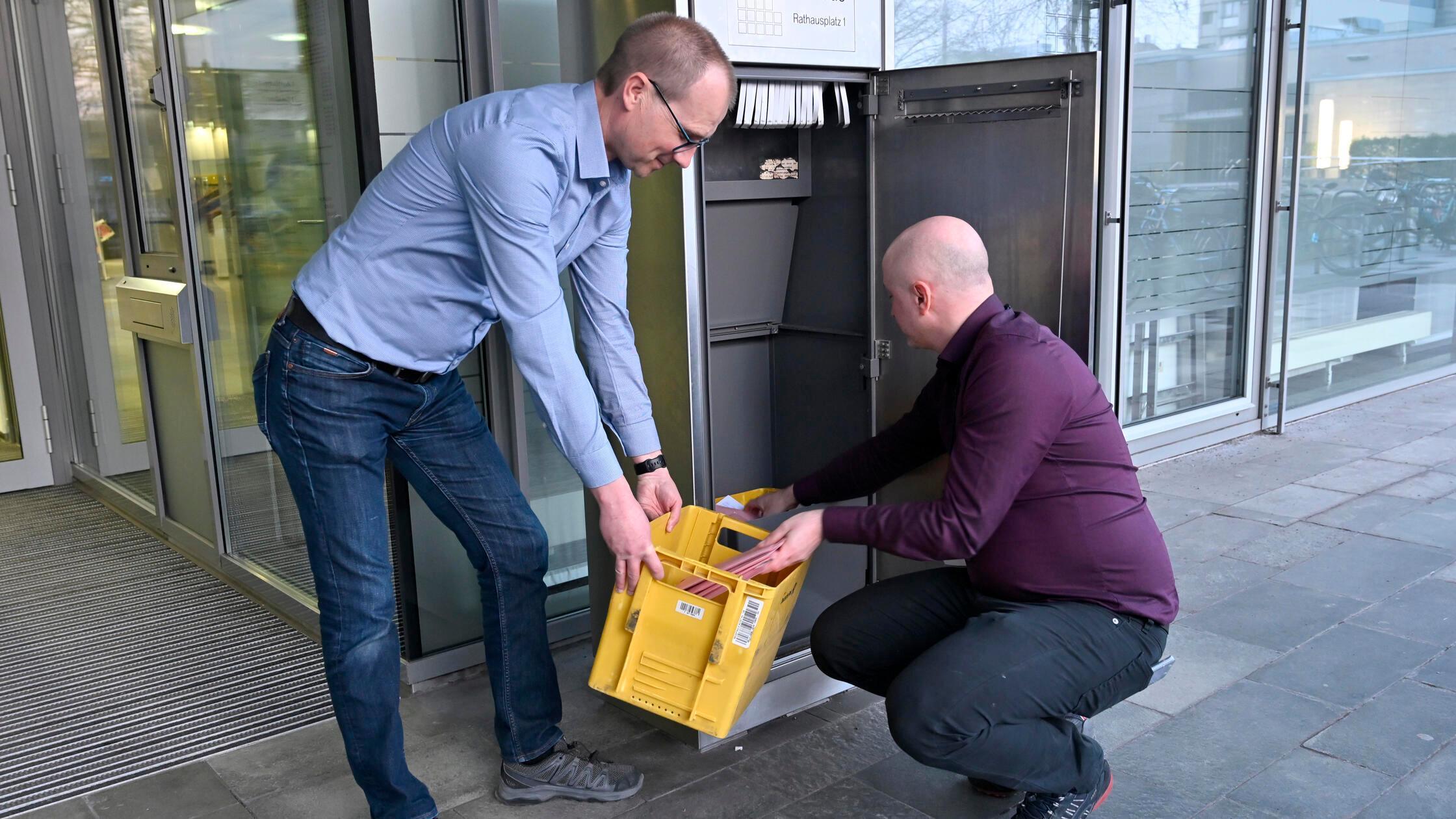 Kommunalwahl in Erlangen 2026: Jürgen Schleicher und Johannes Kremmer leeren Punkt 18 Uhr den Briefkasten vor dem Rathaus. Das waren die letzten Briefwahl-Zusendungen.