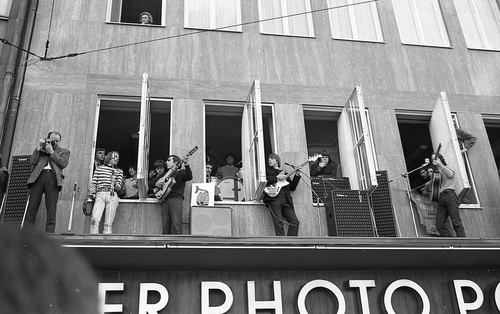 Eine äußerst ungewöhnliche Konzertbühne hatte sich am 23.02.1966 die Beat-Band „Jonah and the Whales“ (aus der später die Band „Ihre Kinder“ hervorgehen sollte) in der Nürnberger Altsstadt gesucht. Die Band kletterte durch die Fenster auf das ungesicherte Vordach des Geschäftes Photo Porst in der Karolinenstrasse 3 und legte los, sehr zur Begeisterung des, bedingt durch die Karnevalszeit, reichlich auf der Straße vorhandenen Publikums. Auch ein Fotograf traute sich damals mit auf das Dach, neben ihm sieht man von links Sonny Hennig, Wuffel Stumm, Roland Multhaupt am Schlagzeug im Fenster, Günter Gast und Ernst Schultz. Der damalige Band-Manager Jonas Porst hat es leider nicht auf unser Bild geschafft.