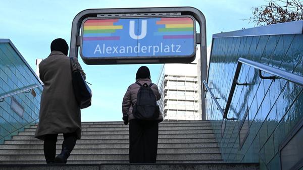 Zwei Frauen mit Kopftuch laufen die Treppe aus der