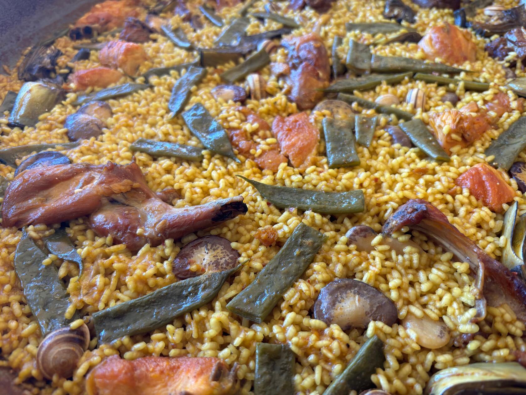 Dort gibt es auch die Paella Valenciana: unter anderem mit Kaninchen, Hühnchen, Muscheln und weißen, wie grünen Bohnen.