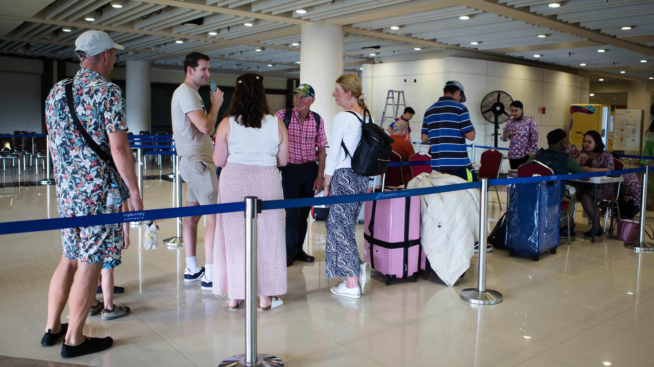 Gestrandete Reisende stehen an einem Informationss