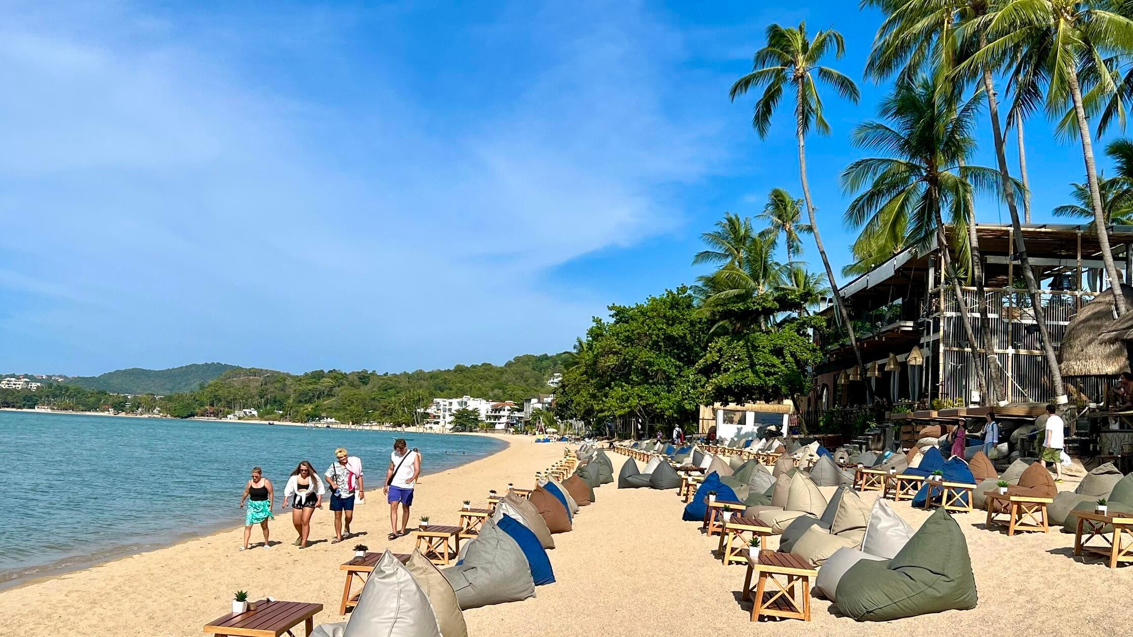 Urlauber spazieren am Strand in Bophut auf der Ins