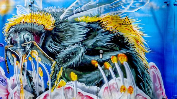 Biene oder Hornisse - diese künstlerische Darstellung zeigt, wie wichtig Bienen für Blumen und Pflanzen sind.