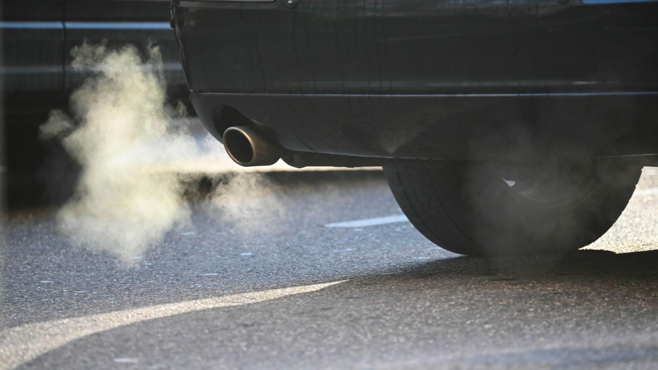 Weißer Rauch ist hinter einem Kraftfahrzeug im Str