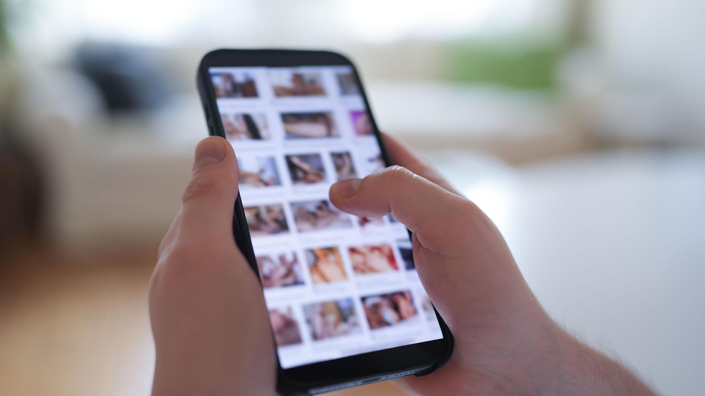 ILLUSTRATION - Ein junger Mann schaut sich auf ein