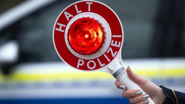 Eine Polizistin hält während einer Verkehrskontrol