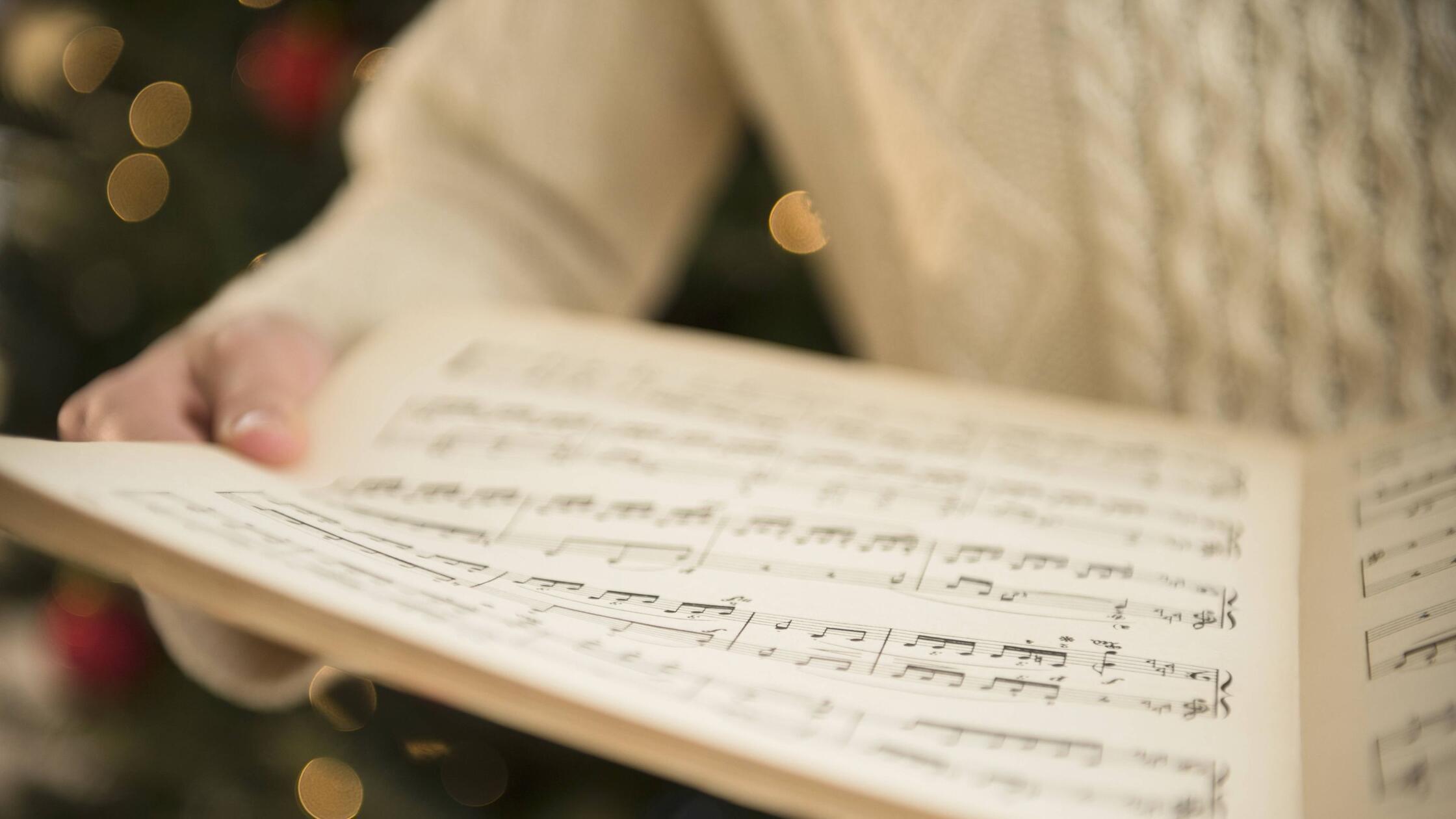 Studio Shot of woman holding sheet music at Christ