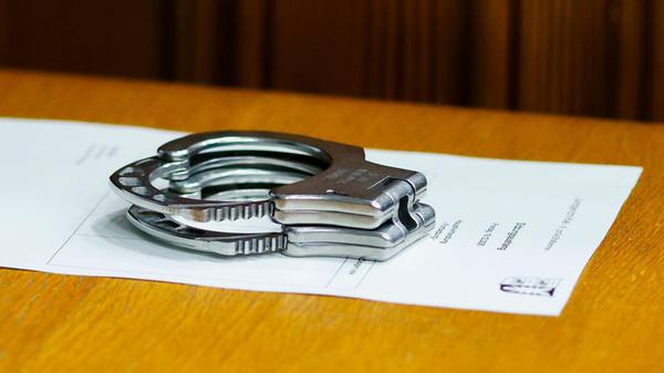 Handschellen liegen auf einem Tisch bei einem Proz