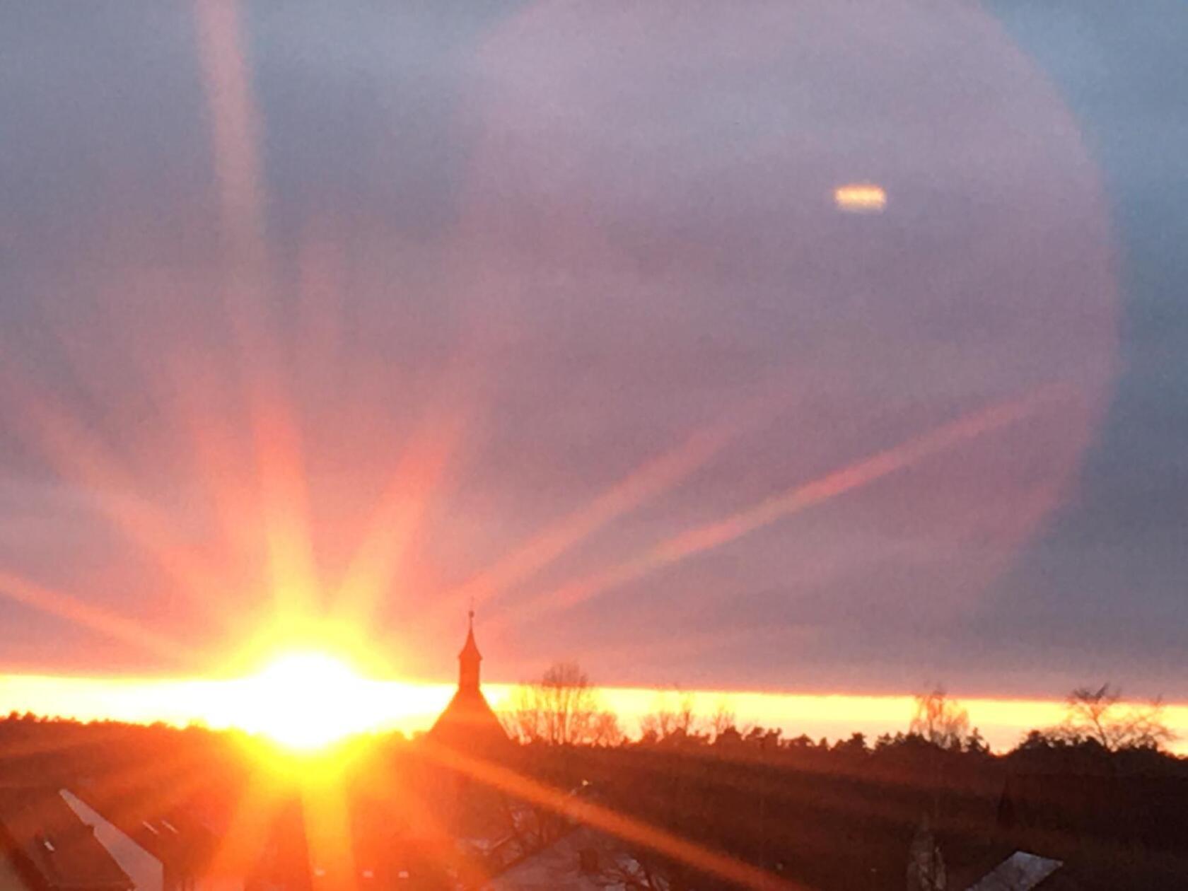 Glühender Sonnenuntergang - langsam versinkt die Sonne hinter der Skyline von Altenfelden. 