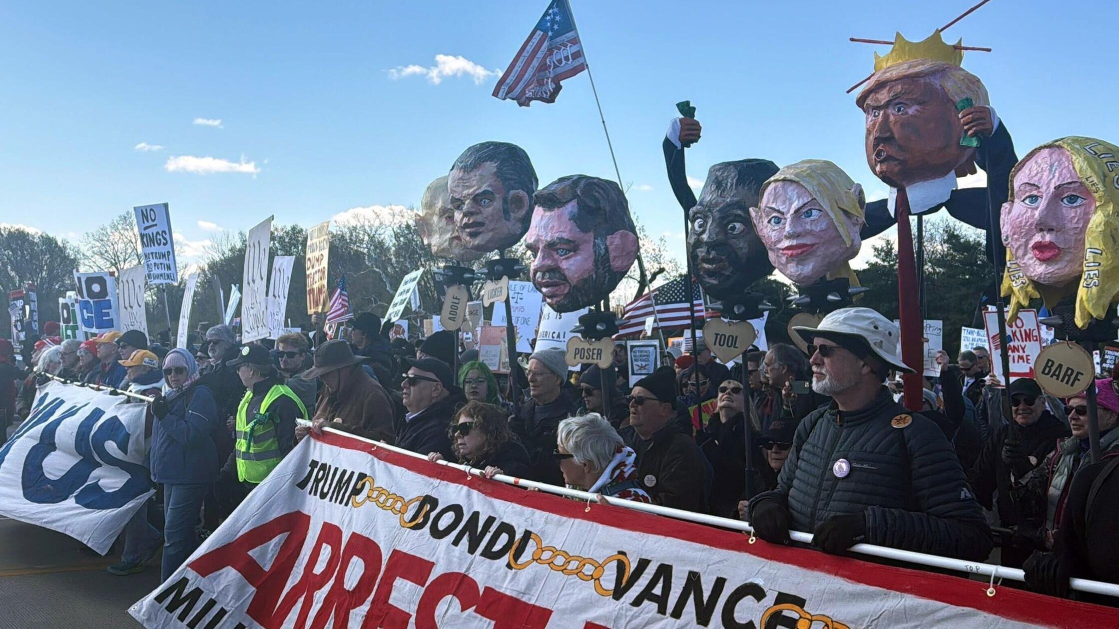 Demonstranten halten Pappköpfe, die Politiker der 