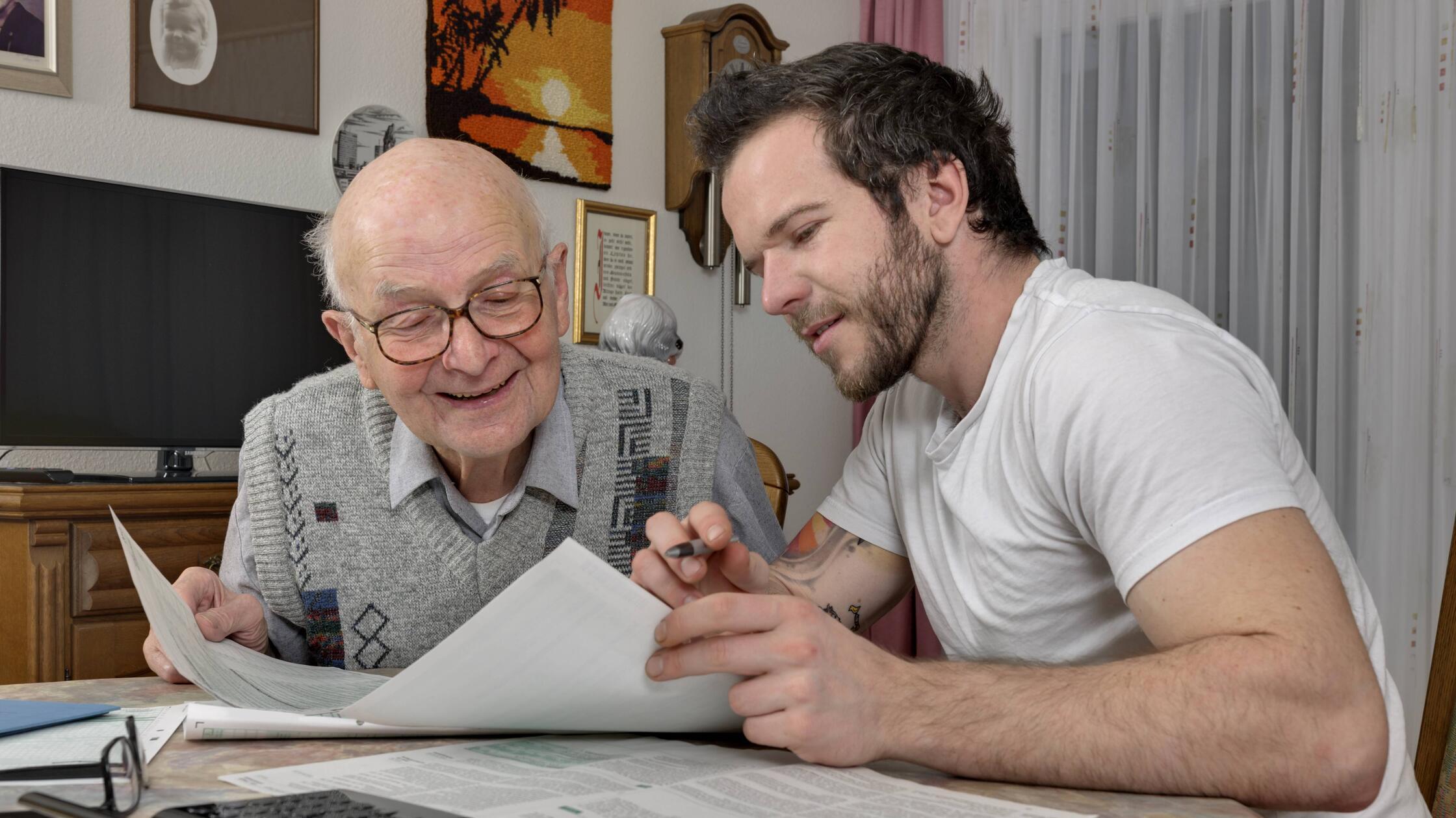 Grandson helping his grandfather by making tax dec