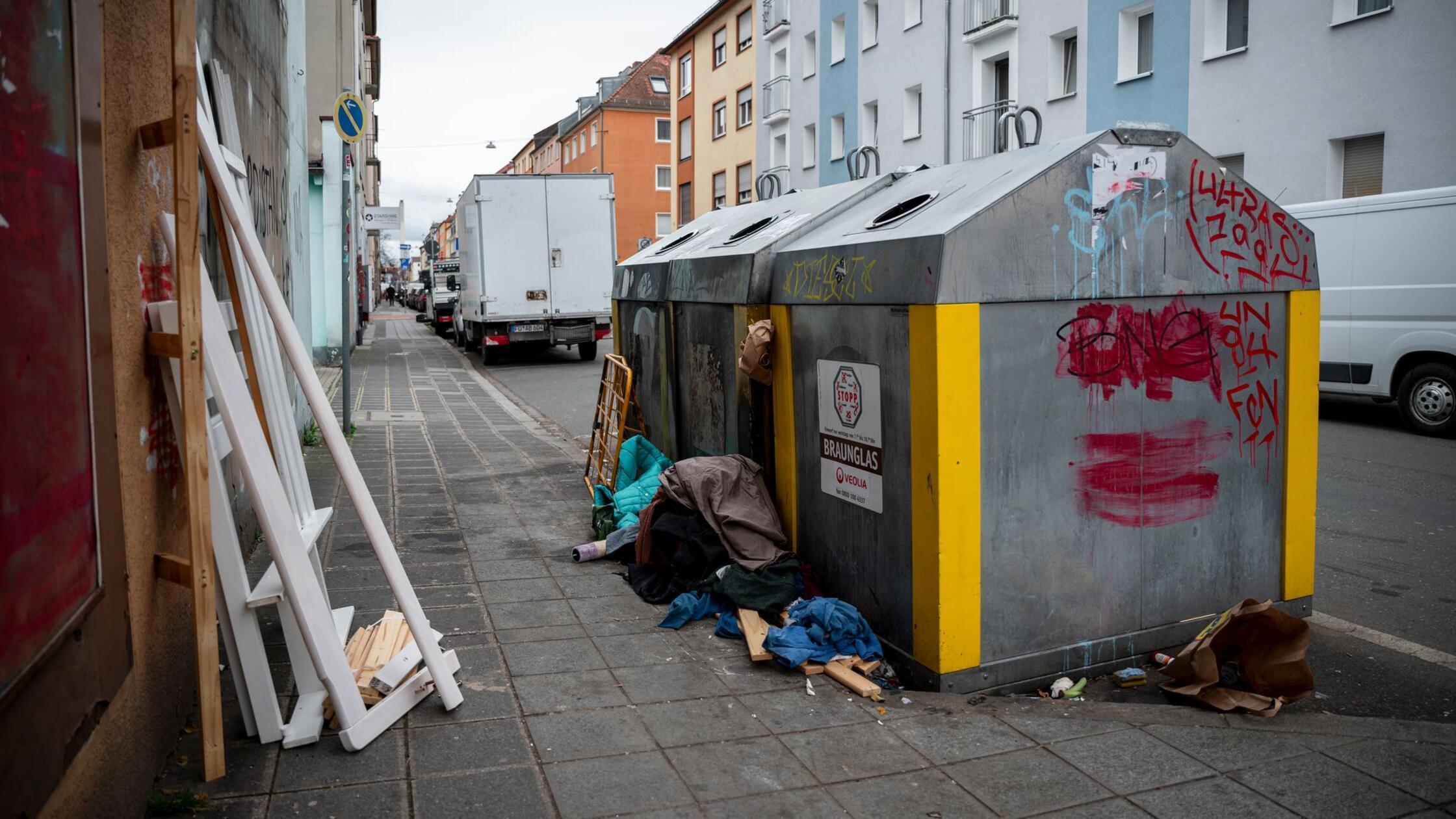 Neben einem Glascontainer liegt Sperrmüll. In der 