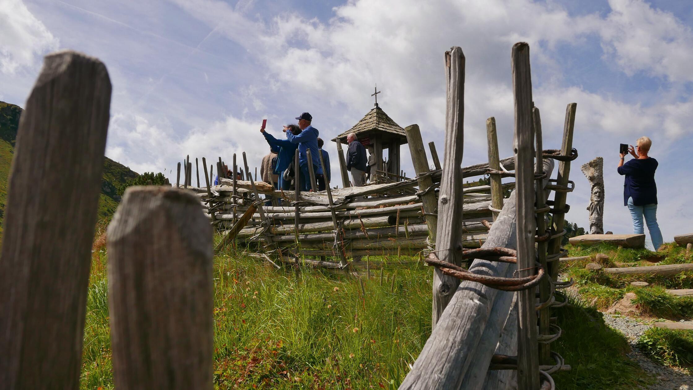 Touristen auf der Nockalmstraße an der Wunschglocke.