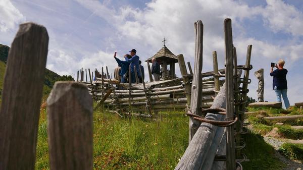 Touristen auf der Nockalmstraße an der Wunschglocke.