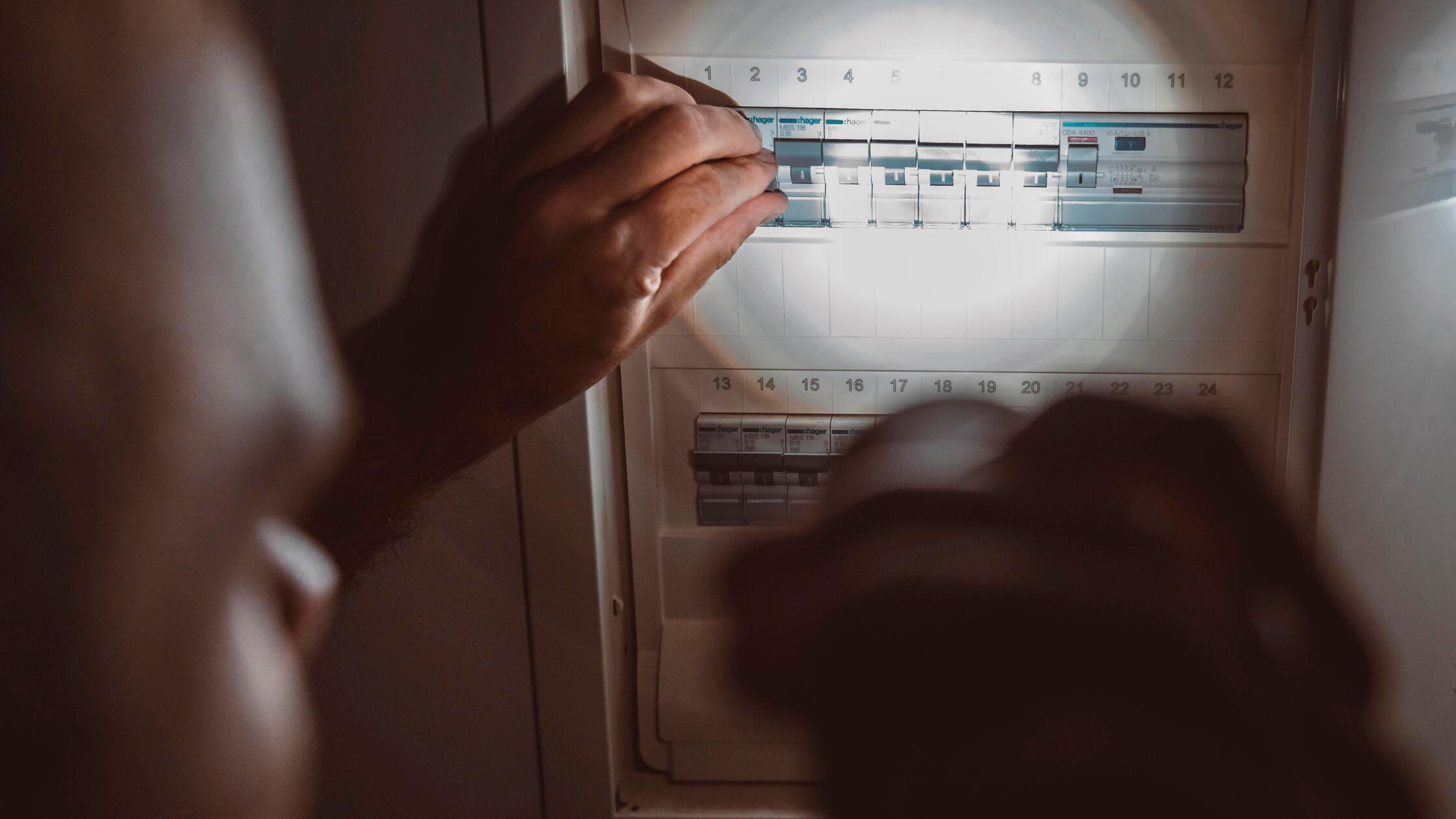 Stromausfall in der Wohnung, Mann leuchtet mit Tas