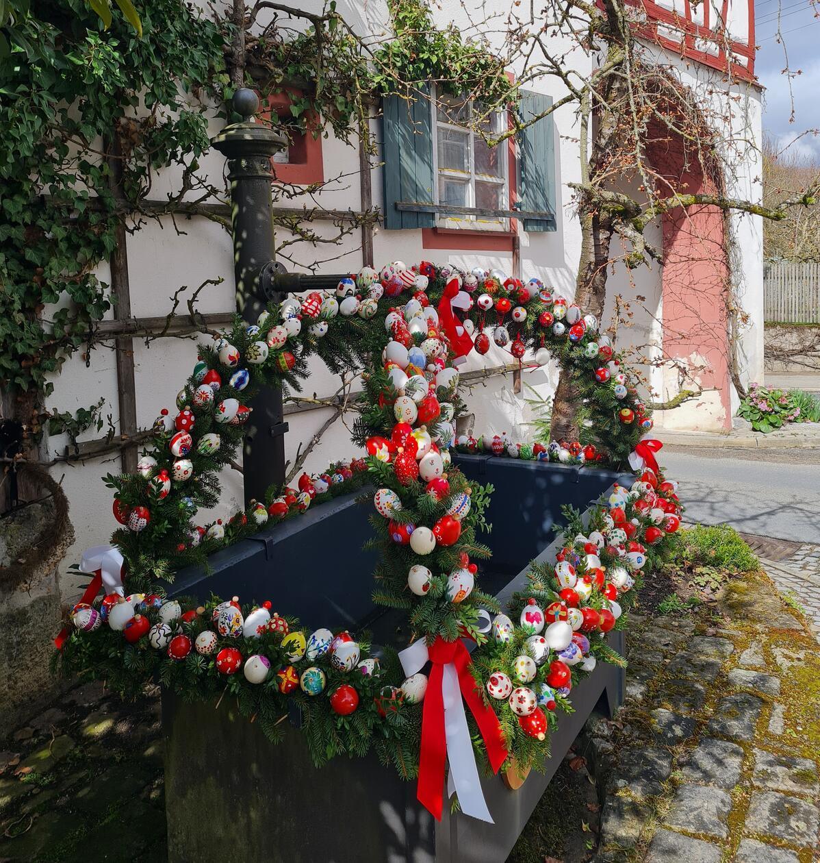 Osterbrunnen neben dem historischen Stadttorbogen in Hiltpoltstein.
