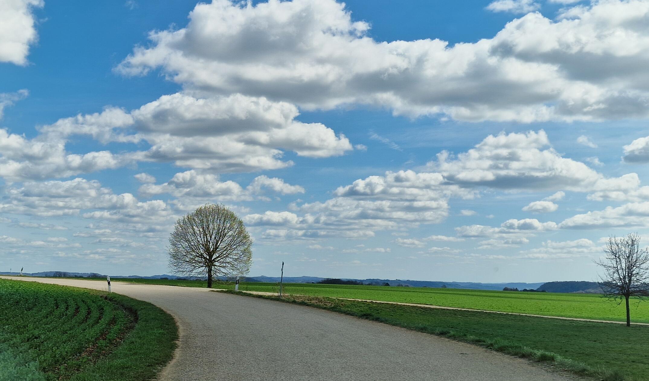 Über der Landstraße wogt ein prächtiges Wolkenmeer.
