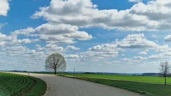 Über der Landstraße wogt ein prächtiges Wolkenmeer.