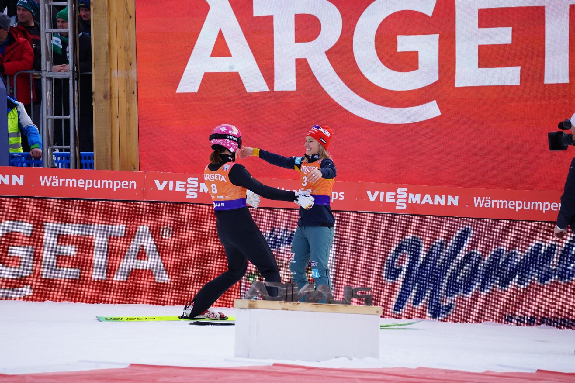 Katharina Schmid und ihre Teamkollegin Agnes Reisch umarmen sich im Auslauf.