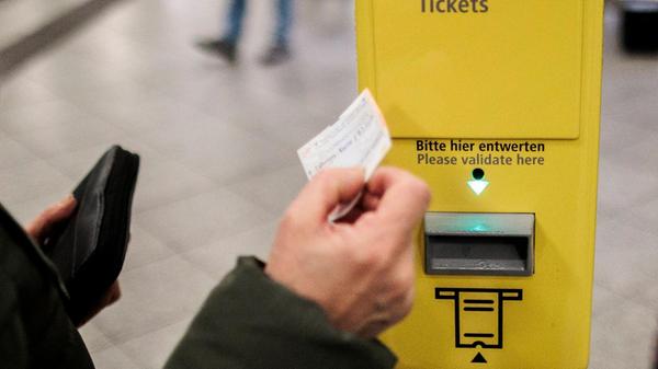 Ein Fahrschein der BVG wird vor einen Entwerter ge