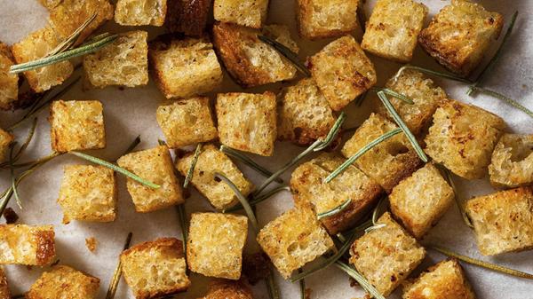 Eine Nahaufnahme von goldenen Croutons und Rosmari