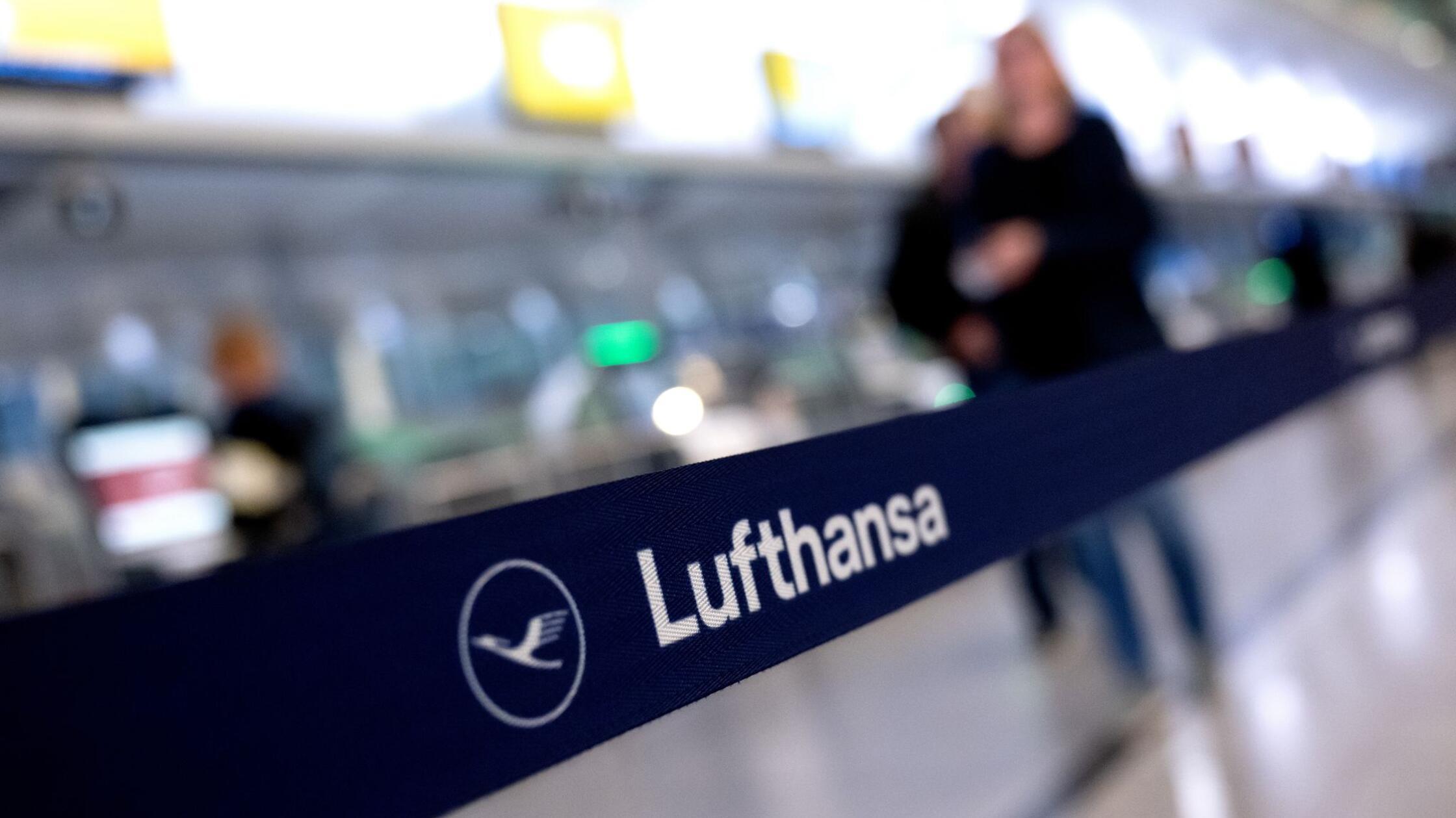 Passagiere stehen am Münchner Flughafen an einem C